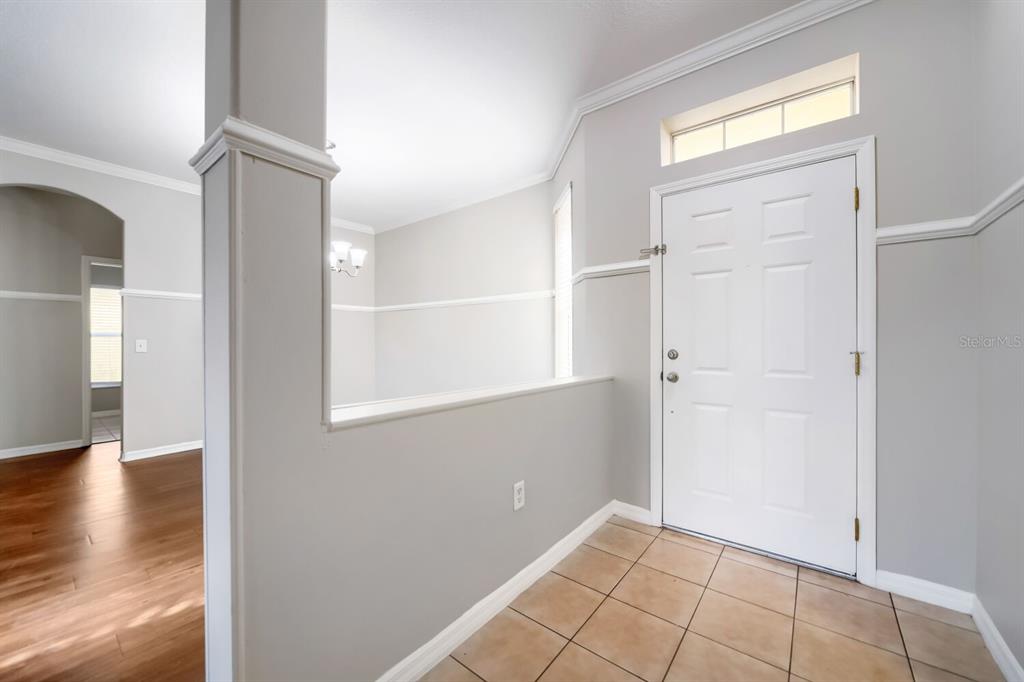An entryway features a tiled floor, a white front door, and a partial wall divider — 380 SORRENTO ROAD, KISSIMMEE, FL