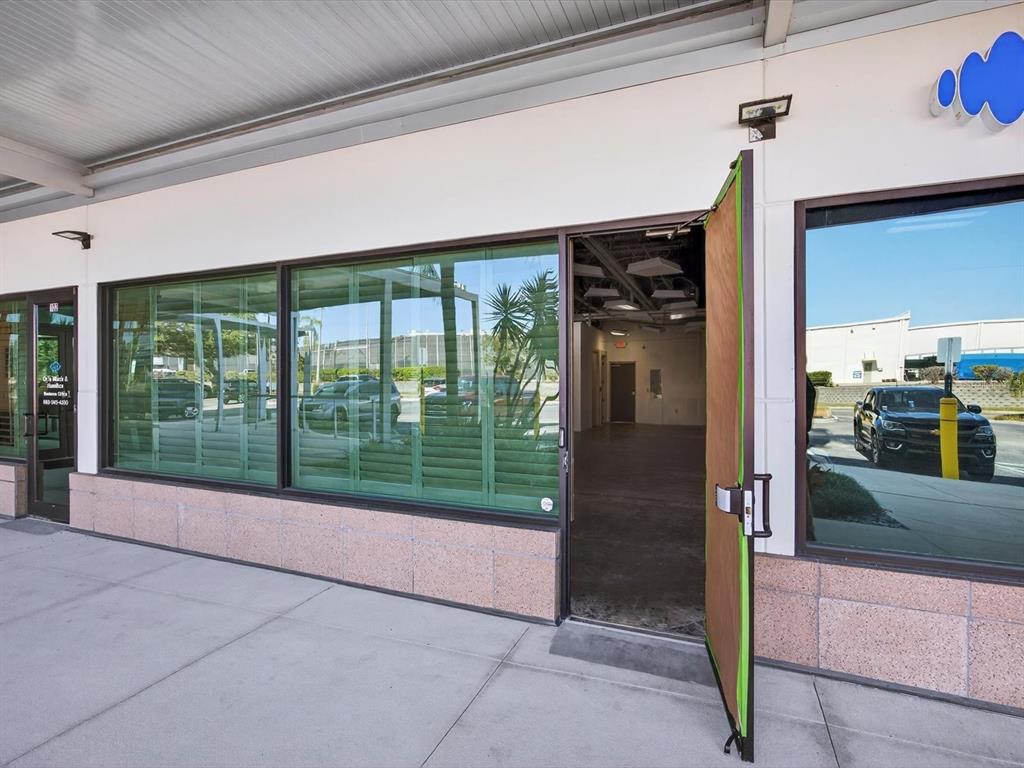 An open door leads into an empty commercial space with a concrete floor and ceiling — 250 AVENUE K SW UNIT 104, WINTER HAVEN, FL