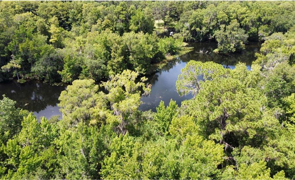 An aerial view of a dark, winding river surrounded by dense green forest and trees — 00 W HIGHWAY 40, DUNNELLON, FL