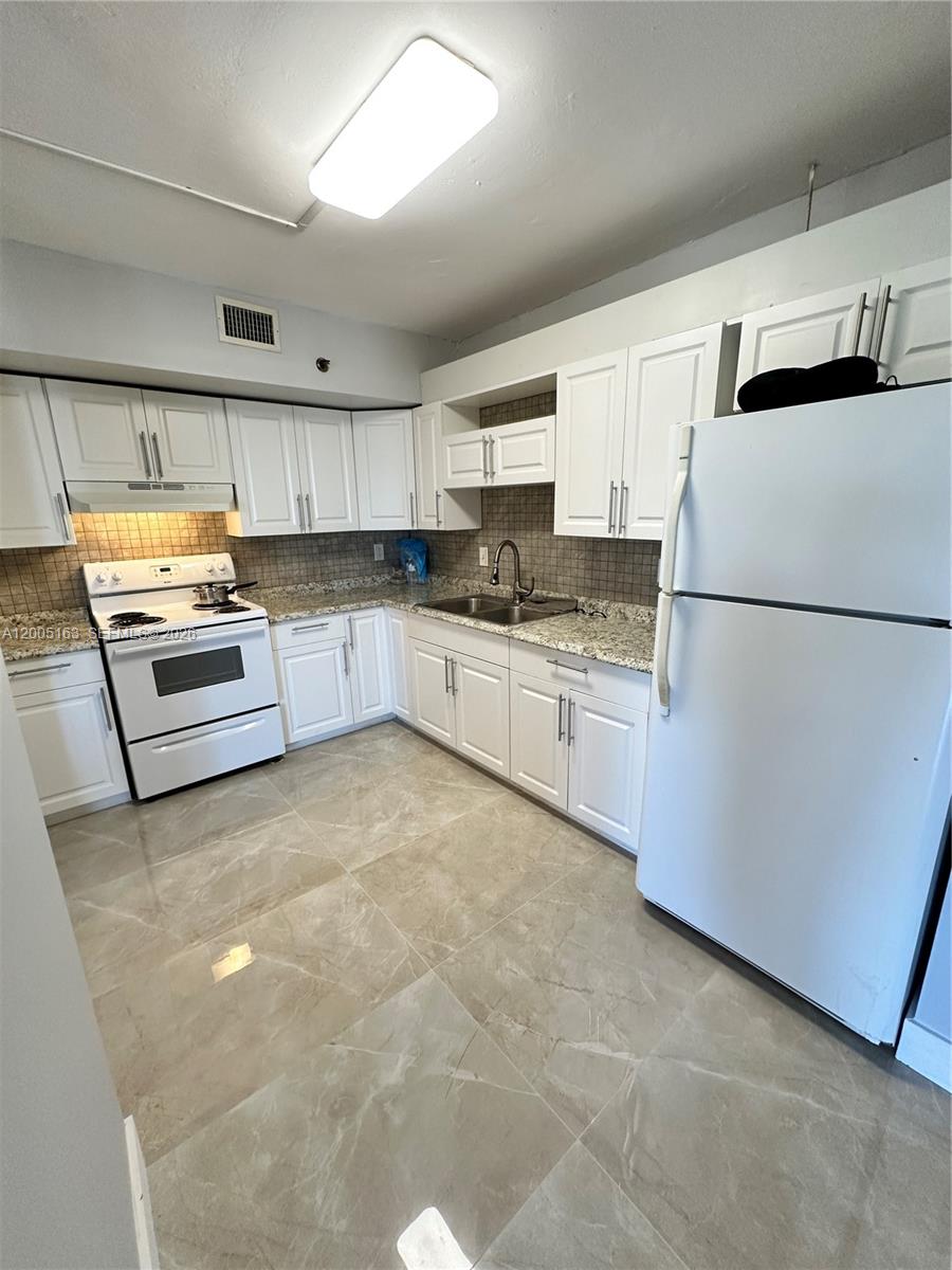 A kitchen features white cabinets, granite countertops, a white stove, and a white refrigerator — 901 Hillcrest Dr # 315, Hollywood FL 33021, HOLLYWOOD, FL