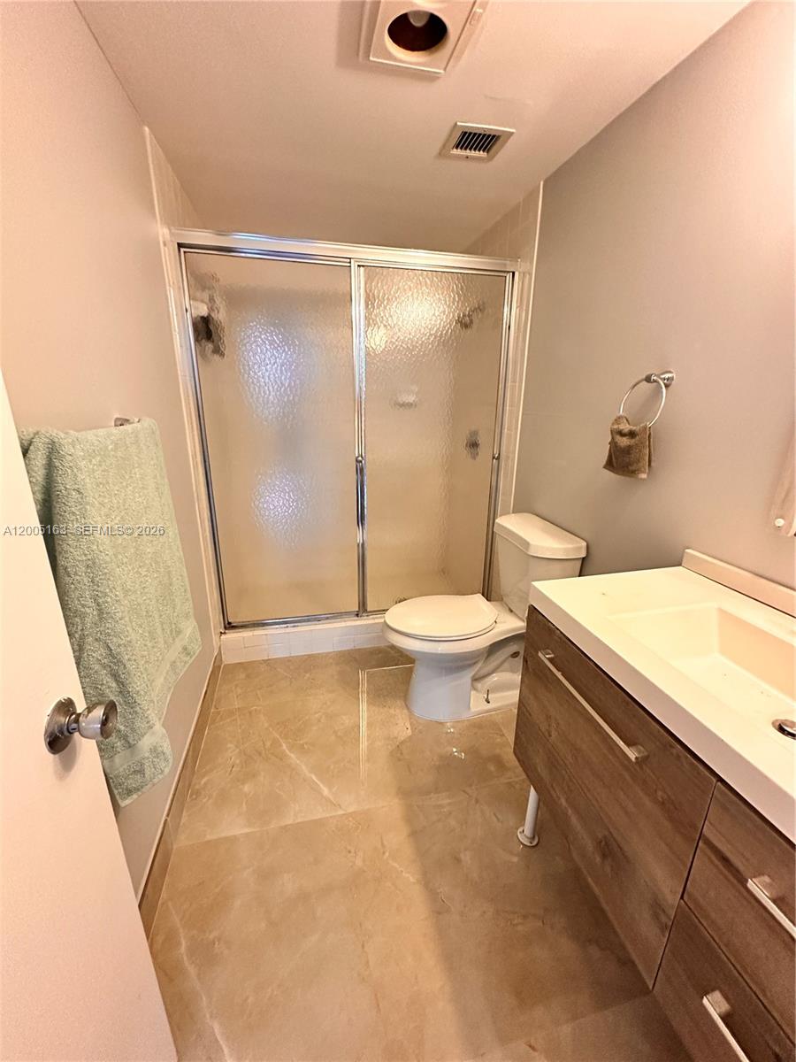 This bathroom features a walk-in shower, a toilet, and a vanity with a wood cabinet — 901 Hillcrest Dr # 315, Hollywood FL 33021, HOLLYWOOD, FL