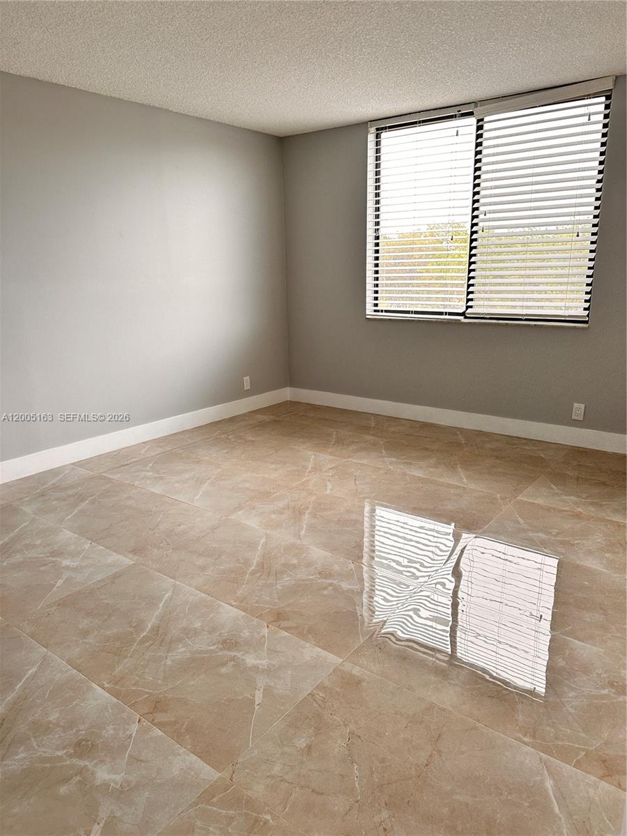 An empty room features light gray walls, large beige tile flooring, and white window blinds — 901 Hillcrest Dr # 315, Hollywood FL 33021, HOLLYWOOD, FL