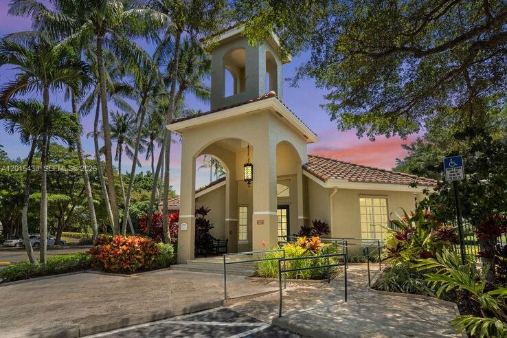 The exterior of a beige building features a bell tower, arched entryway, and palm trees — 5555 N Military Trl, Boca Raton FL 33496, BOCA RATON, FL