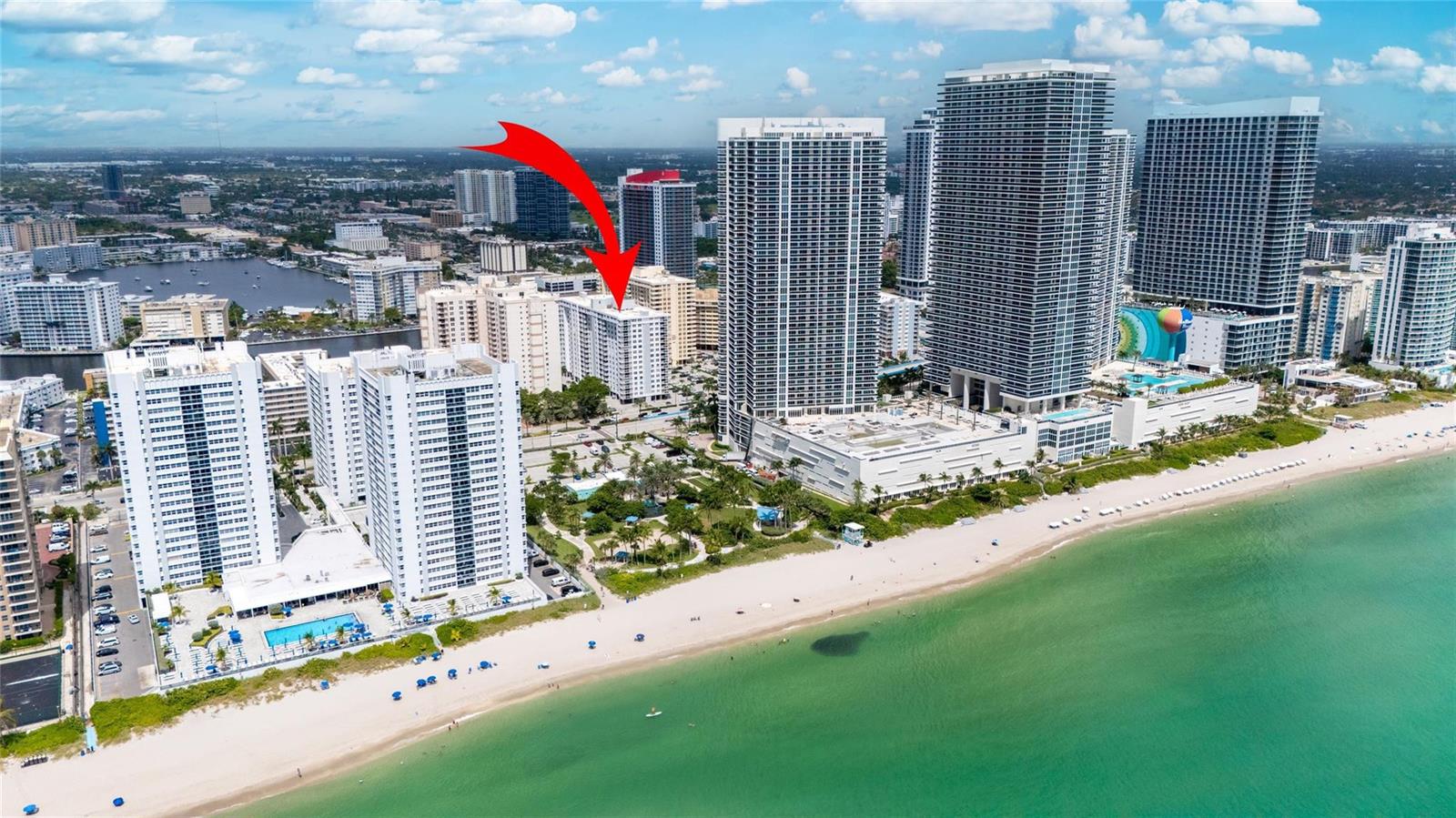 An aerial view shows a white residential building marked by a red arrow near beach — 1849 S Ocean Drive # 711, Hallandale Beach FL 33009, HALLANDALE BEACH, FL