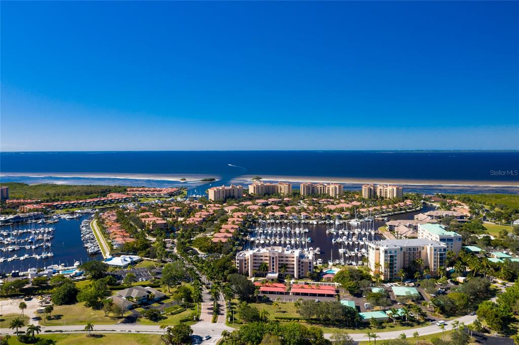 An aerial view shows a coastal residential community with a marina, boat slips, and multi-story buildings — 2060 MATECUMBE KEY ROAD UNIT 2701, PUNTA GORDA, FL