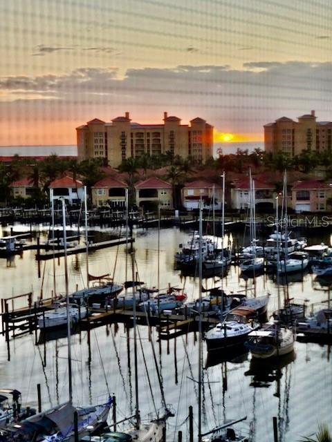A marina filled with sailboats at sunset is viewed through a window screen — 2060 MATECUMBE KEY ROAD UNIT 2701, PUNTA GORDA, FL