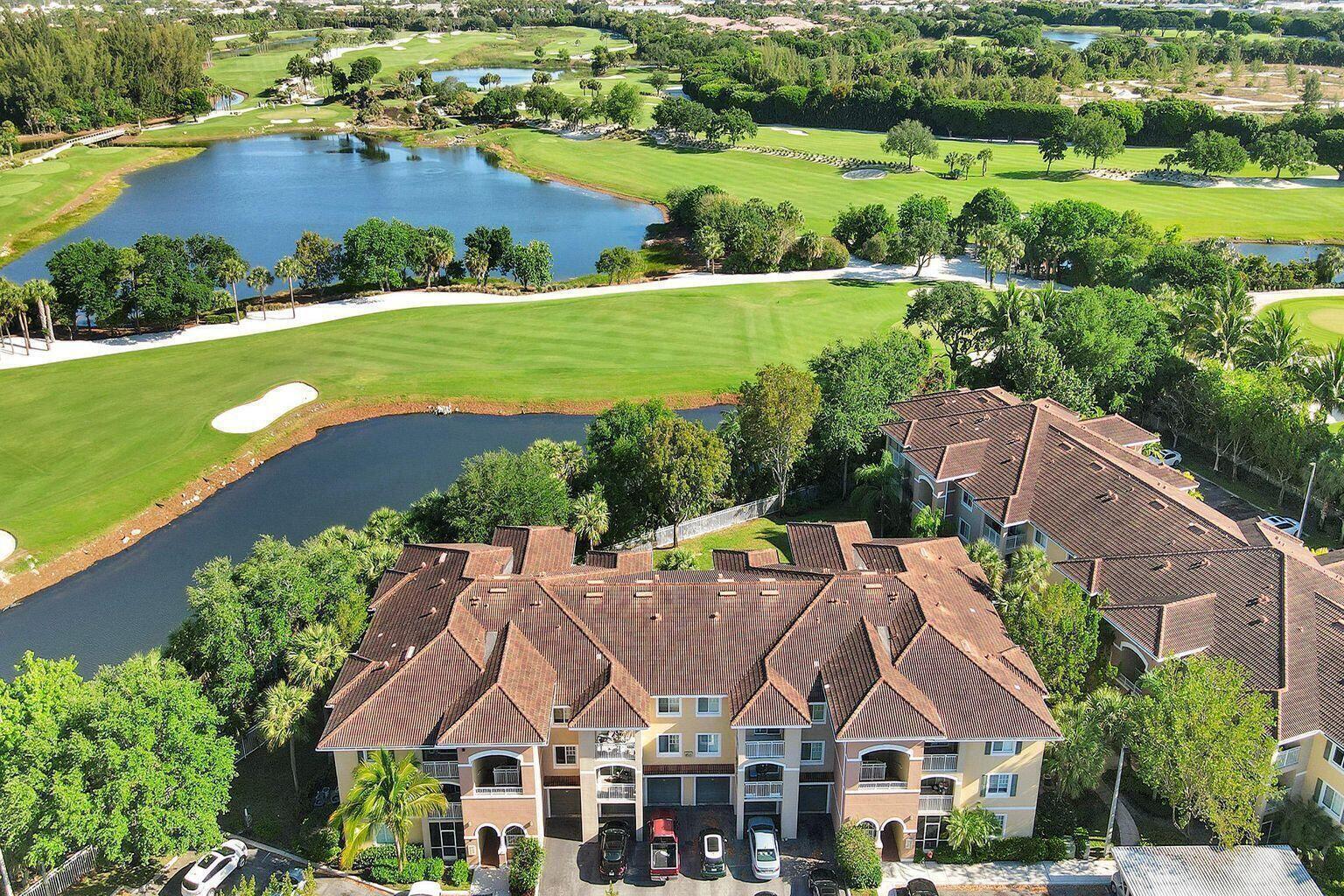 An aerial view of a multi-story residential building overlooking a golf course and lake — 6475 Emerald Dunes Drive # 206, West Palm Beach FL 33411, WEST PALM BEACH, FL