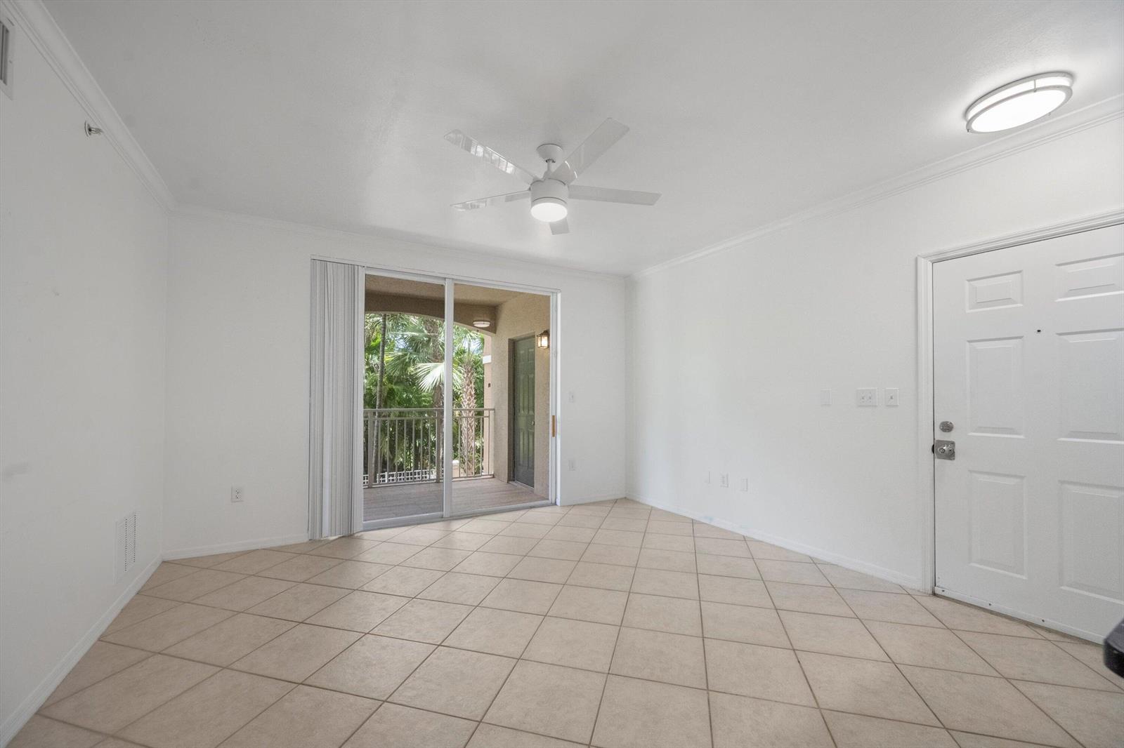 An empty room with white walls, tile flooring, a ceiling fan, and a sliding glass door — 6475 Emerald Dunes Drive # 206, West Palm Beach FL 33411, WEST PALM BEACH, FL