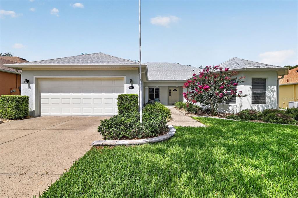 A single-story house with a two-car garage, a concrete driveway, and a front yard — 26821 AUGUSTA SPRINGS CIRCLE, LEESBURG, FL