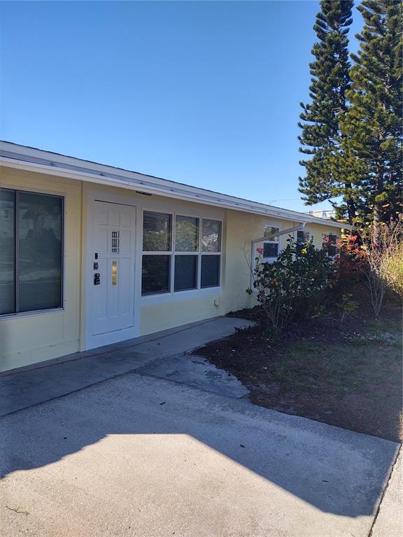 A single-story yellow house with a white door and several windows sits behind a lawn — 3712 W WALLACE AVENUE, TAMPA, FL