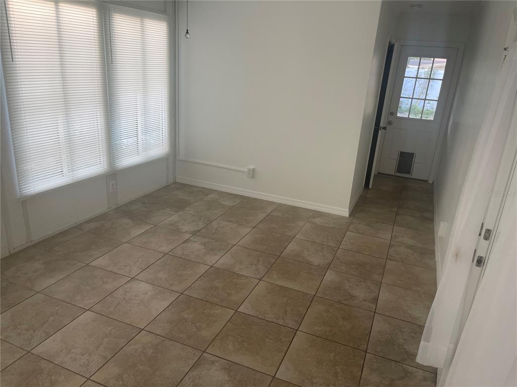 A kitchen features light wood cabinets, white appliances, and dark brown countertops with tile flooring — 3712 W WALLACE AVENUE, TAMPA, FL