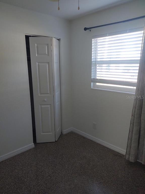 A room with light-colored tile flooring, white walls, large windows with blinds, and a door — 3712 W WALLACE AVENUE, TAMPA, FL