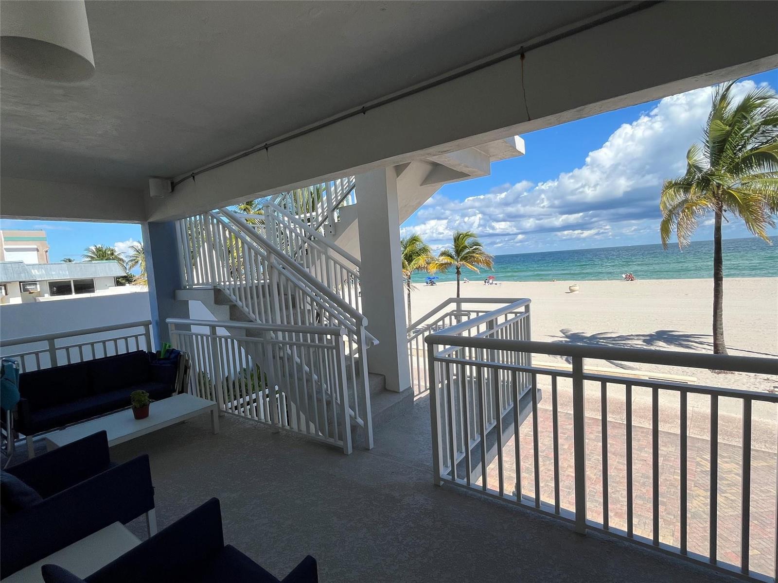 A covered patio features outdoor seating and stairs leading directly to a sandy beach — 310 S Broadwalk # 3b, Hollywood FL 33019, HOLLYWOOD, FL