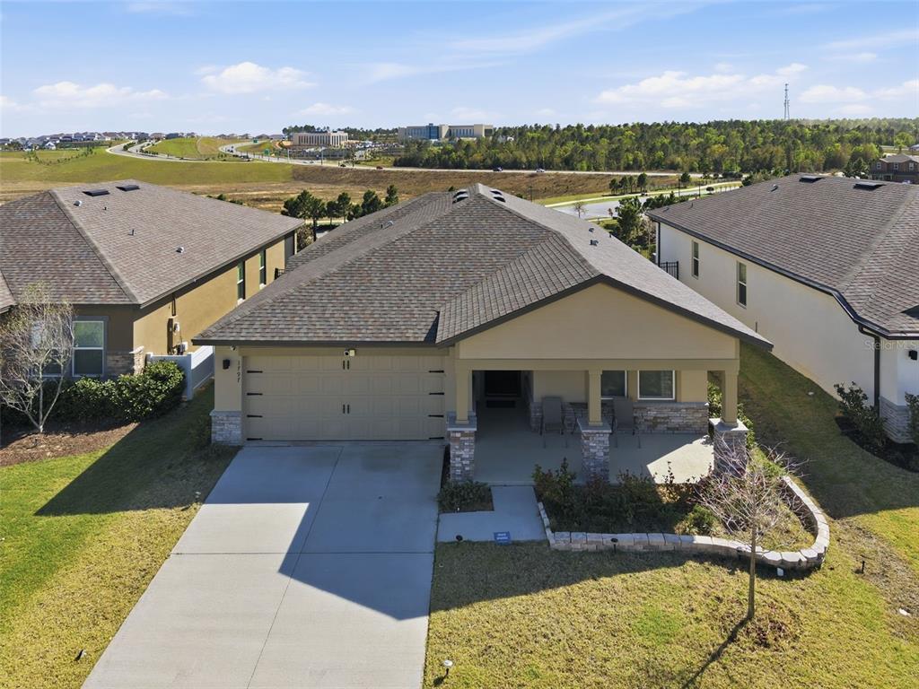 An aerial view of a single-story suburban house with a two-car garage and front porch — 1797 SUNDANCE CHASE ROAD, MINNEOLA, FL