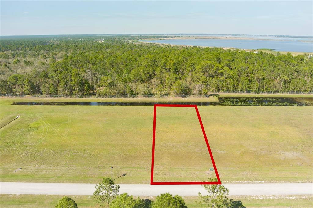 An aerial view shows a vacant rectangular lot outlined in red bordering a paved road — 4540 LINDBERGH            LOT 94 DRIVE, FROSTPROOF, FL