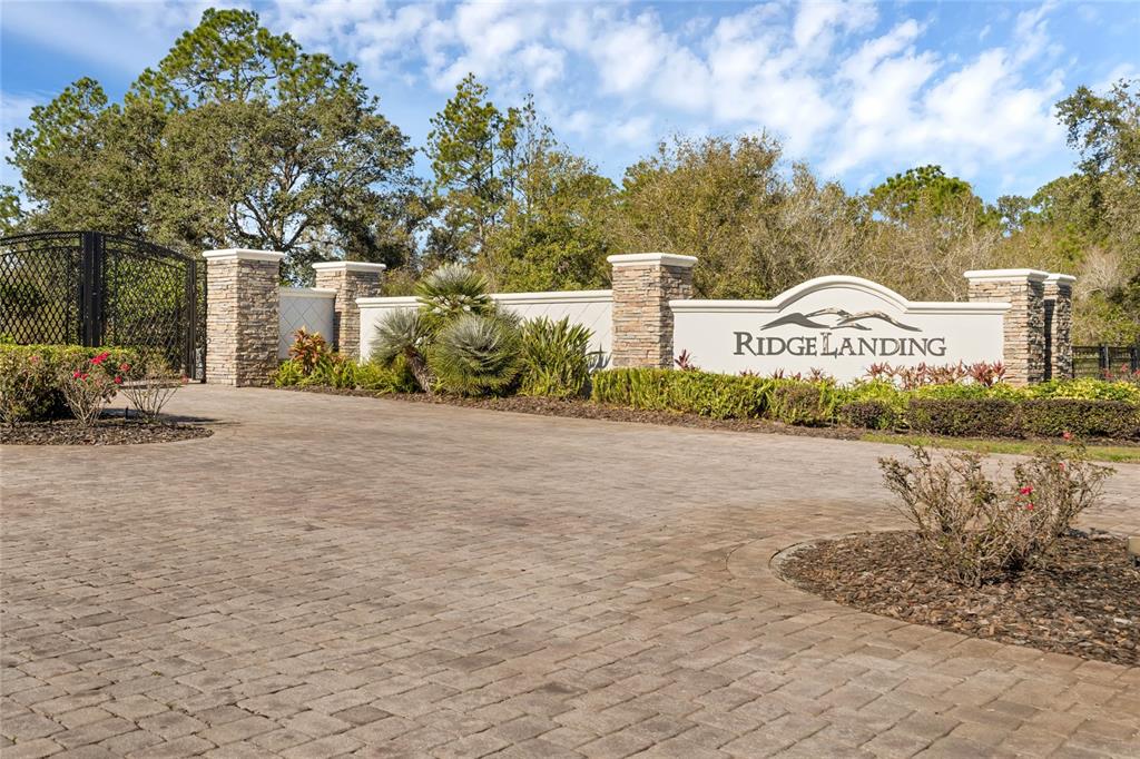 A stone-accented entrance sign for Ridge Landing stands behind a paved driveway and landscaping — 4540 LINDBERGH            LOT 94 DRIVE, FROSTPROOF, FL
