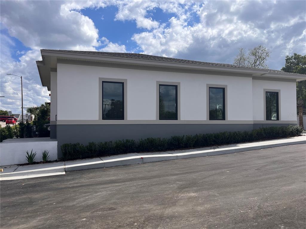 A side view of a white and gray commercial building with four dark-framed windows — 370 MAPLE STREET, ALTAMONTE SPRINGS, FL