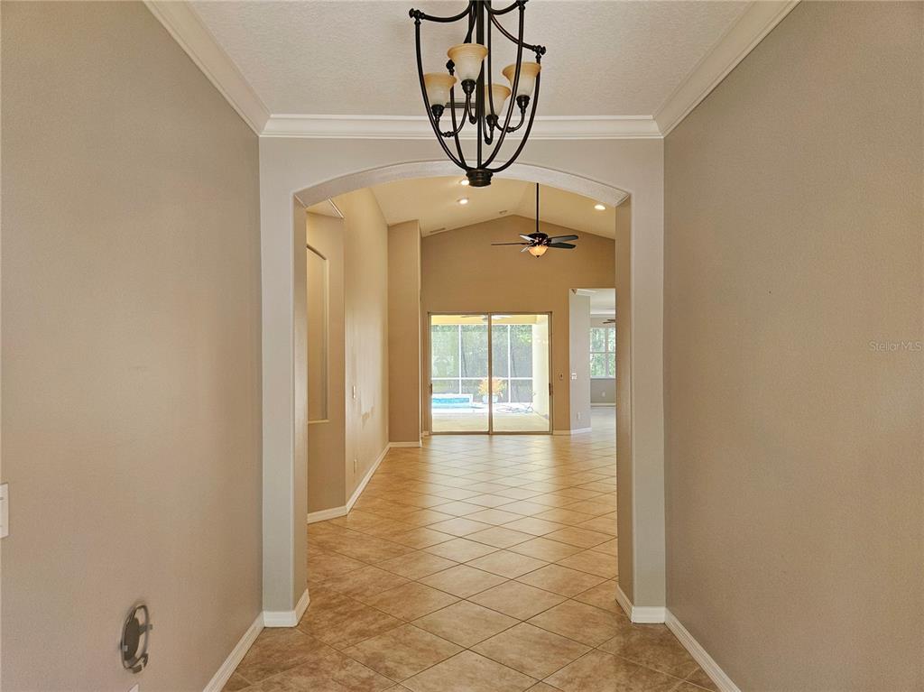 A tiled entryway leads through an arched opening toward a living area with sliding doors — 12112 MAPLE RIDGE DRIVE, PARRISH, FL
