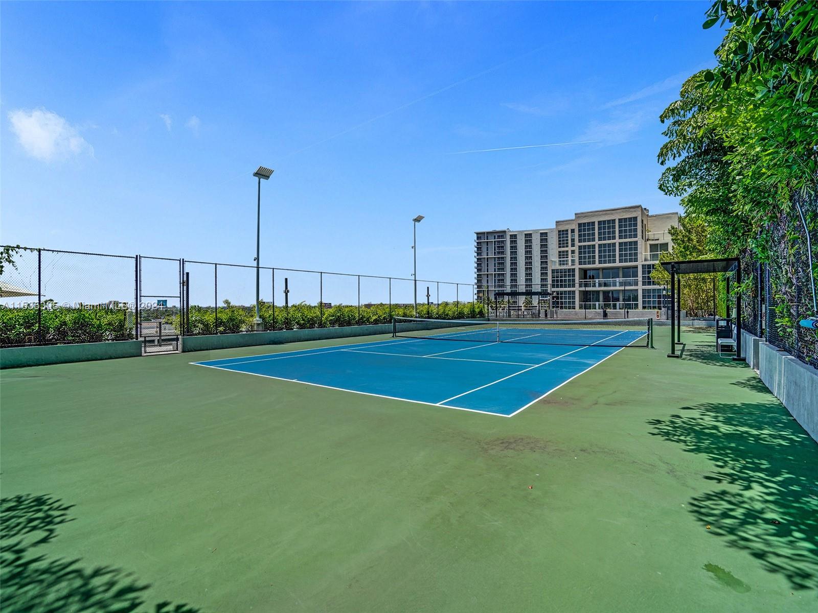 A blue and green outdoor tennis court sits in front of a large residential building — 121 NE 34th St # 1801, Miami FL 33137, MIAMI, FL