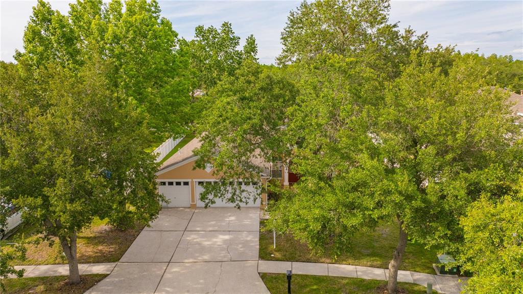 An aerial view of a suburban house with a two-car garage and mature trees — 6028 CATLIN DRIVE, TAMPA, FL