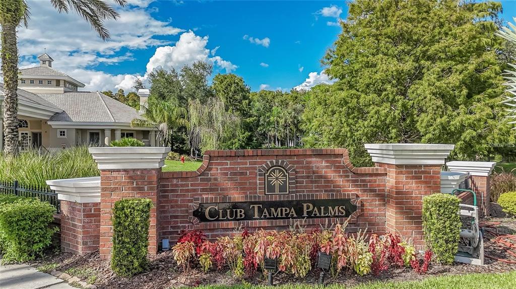A brick monument sign for Club Tampa Palms stands in front of a large clubhouse — 6028 CATLIN DRIVE, TAMPA, FL