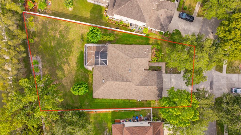 An aerial view shows a house with a screened pool enclosure on a large lot — 6028 CATLIN DRIVE, TAMPA, FL