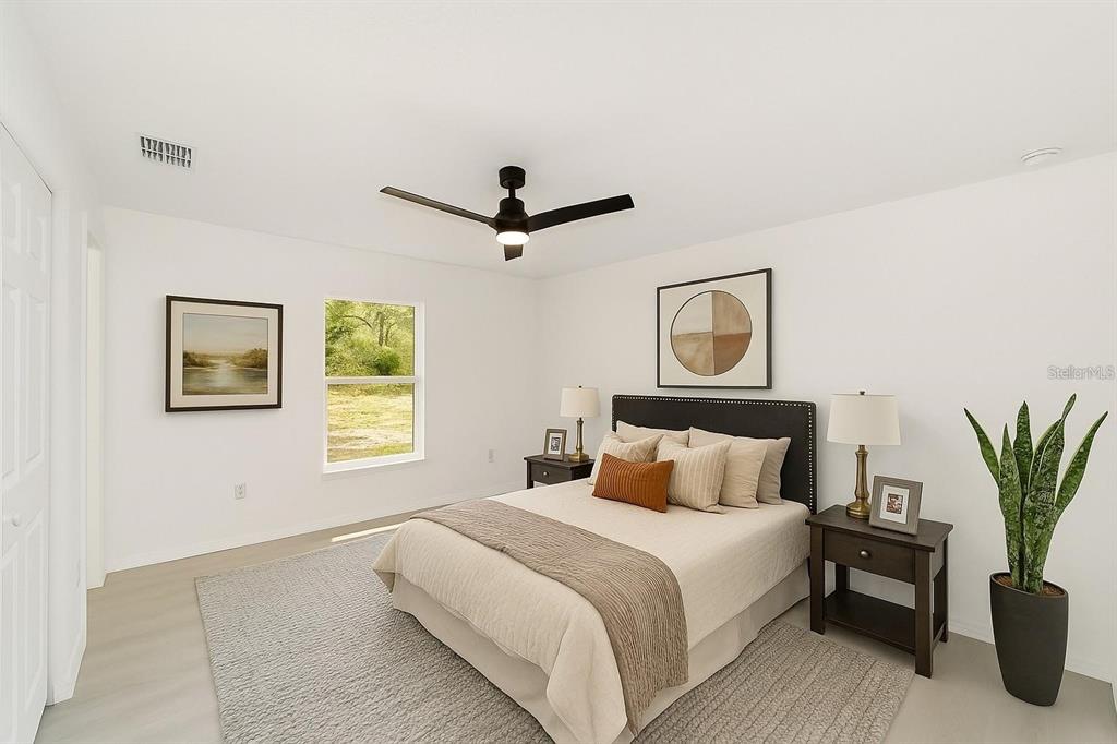 An open-concept living room and kitchen with light wood flooring and a ceiling fan — 1870 SW OBEE RIDGE ROAD, DUNNELLON, FL