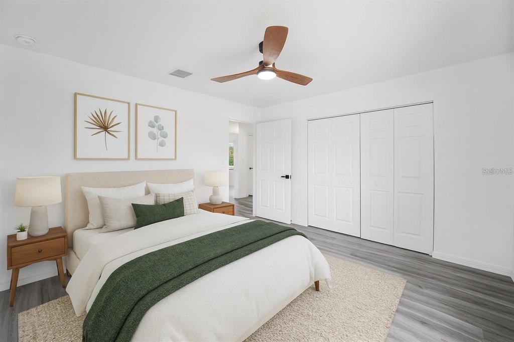 A bedroom features a bed with a dark headboard, a ceiling fan, and a window — 1870 SW OBEE RIDGE ROAD, DUNNELLON, FL