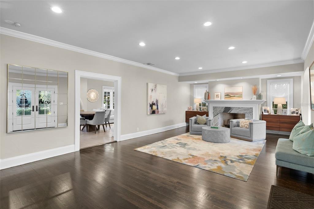 A living room with dark hardwood floors, a stone fireplace, and a large area rug — 2943 W BAYSHORE COURT, TAMPA, FL