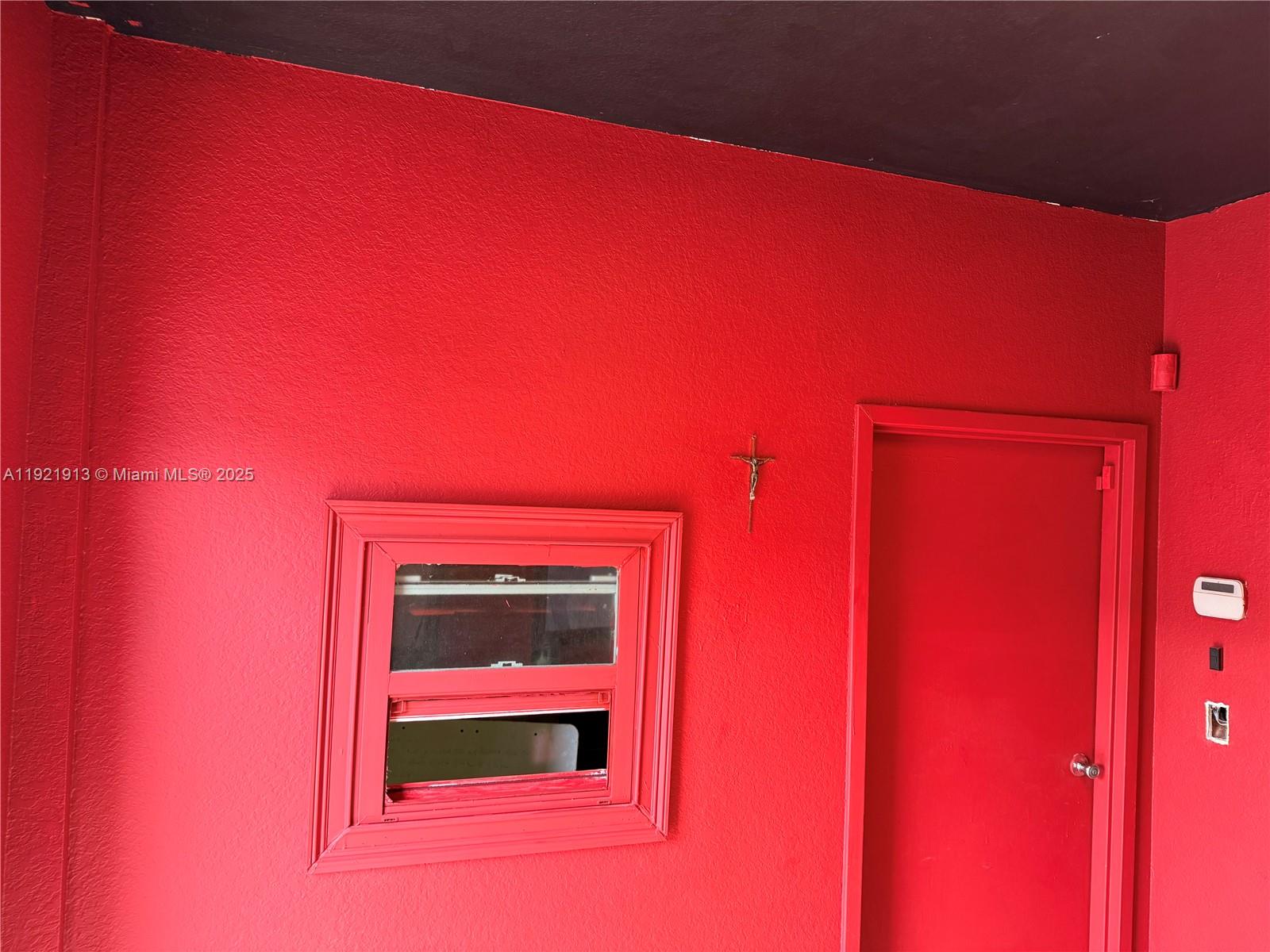 A bright red exterior wall features a window, a door, and a small crucifix — 16205 SW 117th Ave # 3, Miami FL 33177, MIAMI, FL