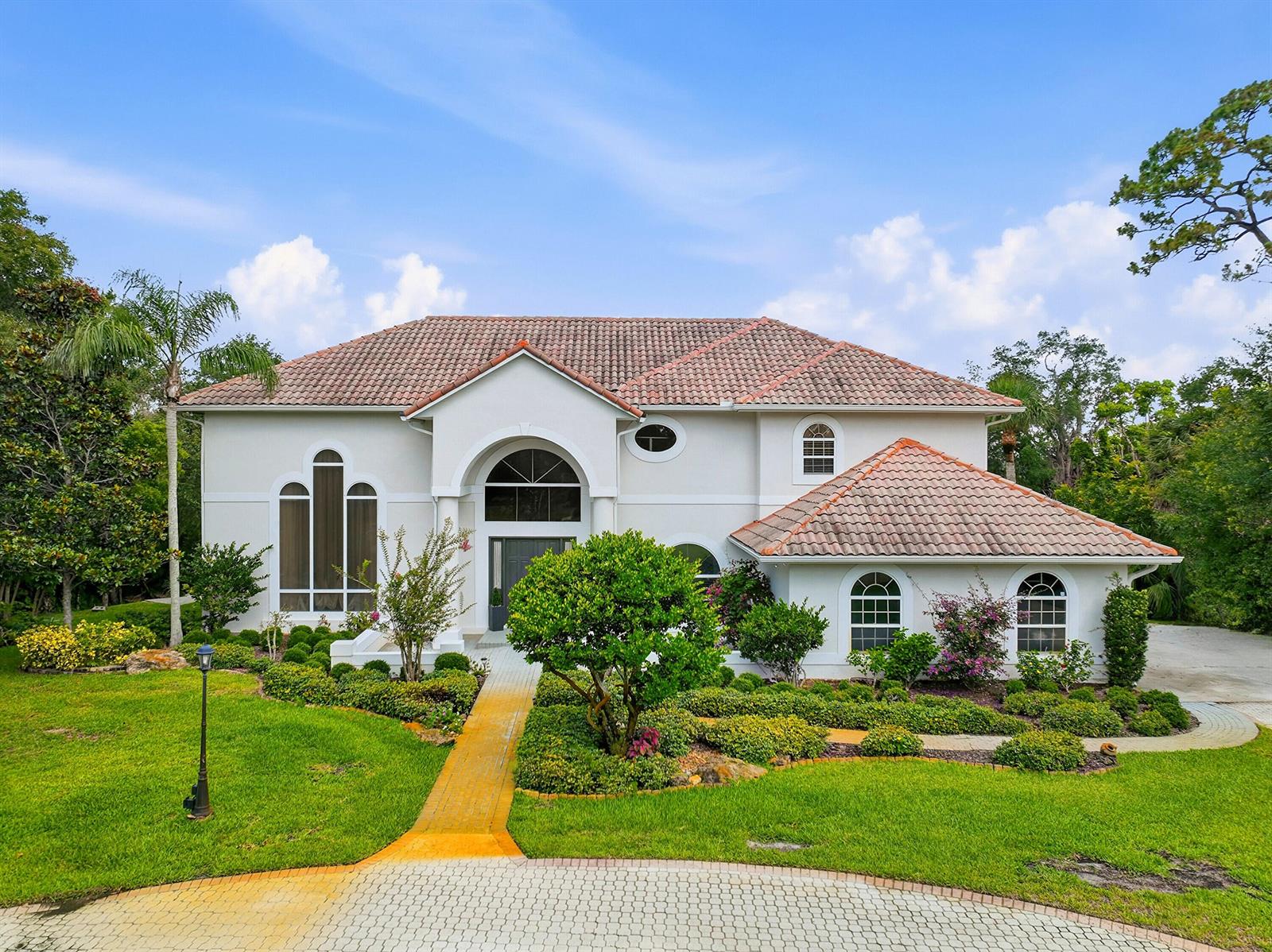 A two-story house with a white exterior, tile roof, and a paved walkway — 12765 Roseland Road, Sebastian FL 32958, SEBASTIAN, FL