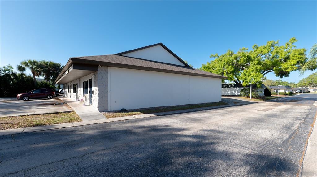 A single-story commercial building with a stone facade and a dark shingled roof — 190 PATRICIA AVENUE UNIT 3, DUNEDIN, FL