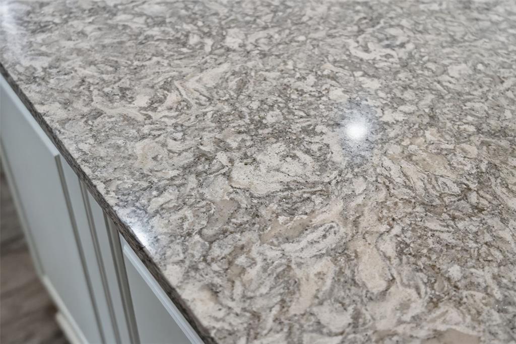A close-up view of a kitchen countertop with a gray and white patterned stone finish — 12758 SORRENTO WAY, BRADENTON, FL