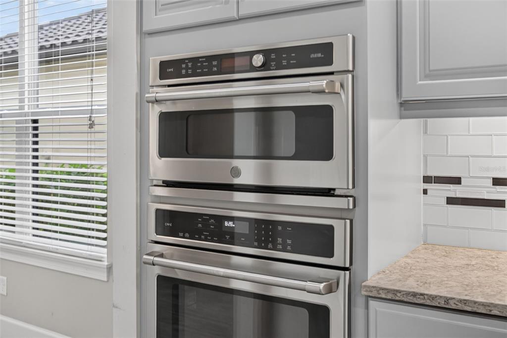 A stainless steel double wall oven is installed in a kitchen with gray cabinets — 12758 SORRENTO WAY, BRADENTON, FL
