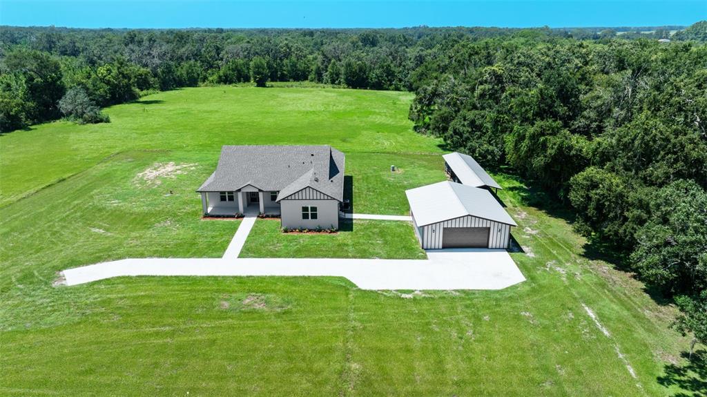 An aerial view shows a house and a detached garage on a large grassy lot — 13219 NEWGENT ROAD, SAN ANTONIO, FL