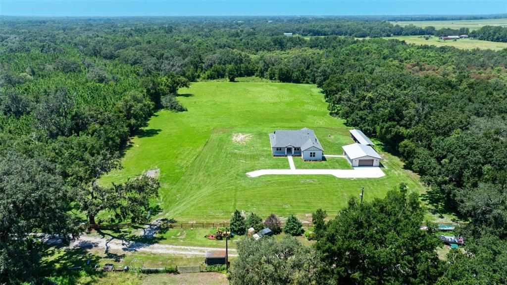 An aerial view shows a house and detached garage on a large, grassy rural lot — 13219 NEWGENT ROAD, SAN ANTONIO, FL