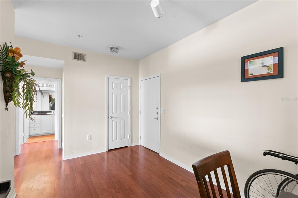 A room with hardwood floors, two white doors, and a framed picture on the wall — 501 KNIGHTS RUN AVENUE UNIT 1310, TAMPA, FL