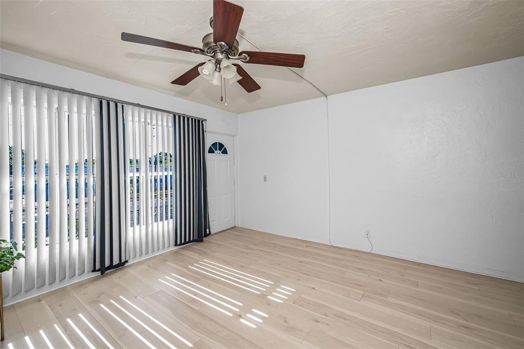 A room with light wood-look flooring, white walls, a ceiling fan, and vertical window blinds — 4051 58TH STREET N UNIT 243, KENNETH CITY, FL