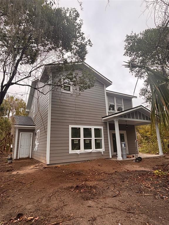 A two-story house with gray siding, a covered porch, and a side entrance door — 1307 OCEAN STREET, PALATKA, FL