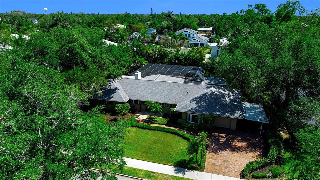An aerial view shows a single-story house with a gray roof and screened-in pool area — 1714 SOUTH DRIVE, SARASOTA, FL