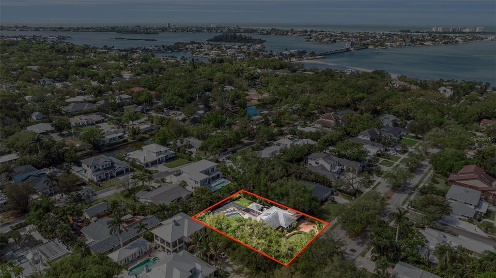 An aerial view shows a residential property with a pool and lush landscaping outlined in red — 1714 SOUTH DRIVE, SARASOTA, FL