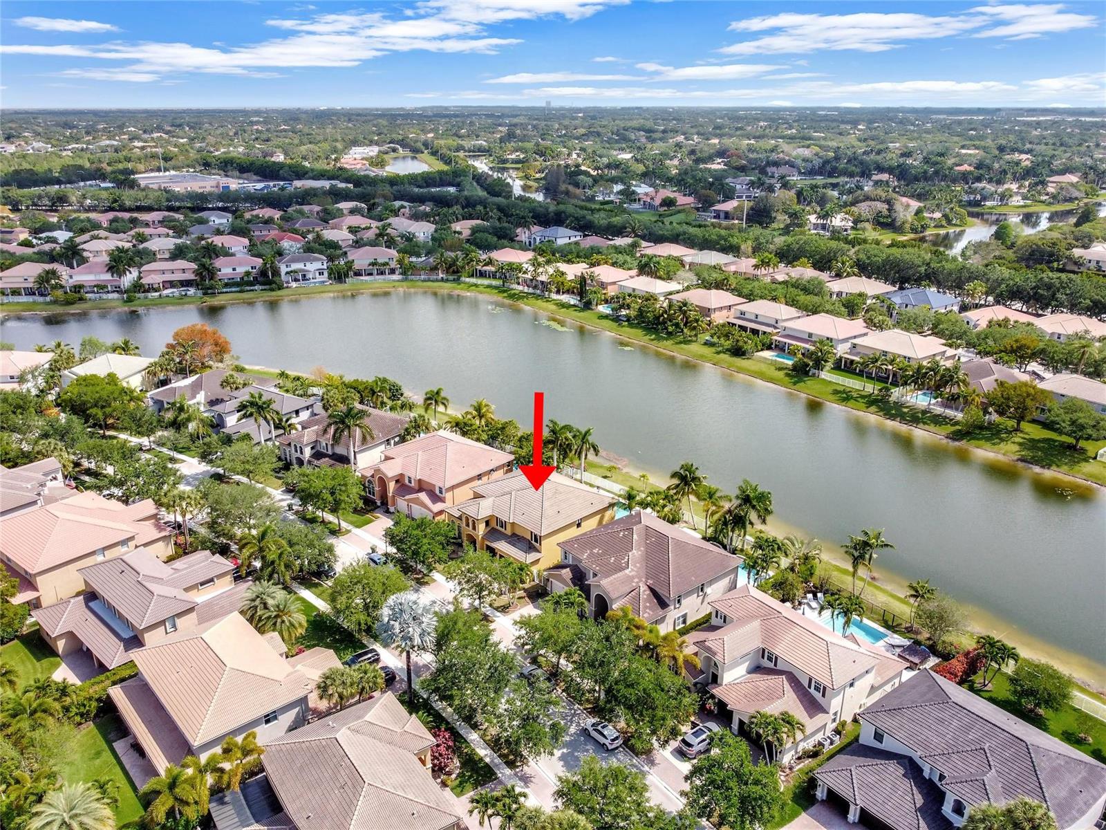 An aerial view shows a yellow house with a red arrow pointing to its roof — 3872 W Hibiscus Street, Weston FL 33332, WESTON, FL