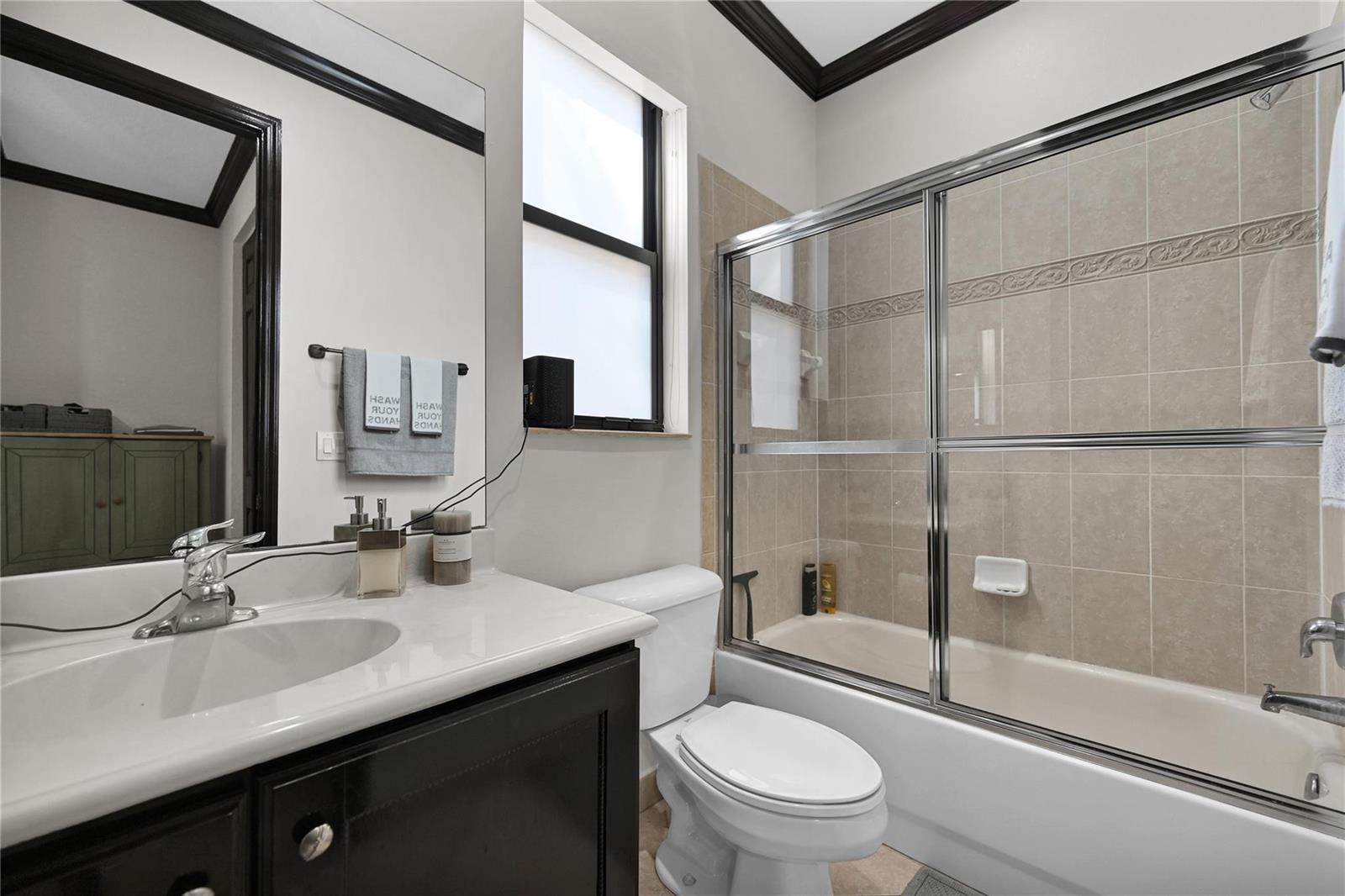 A bathroom features a dark vanity, a white toilet, and a tiled shower-tub combination — 3872 W Hibiscus Street, Weston FL 33332, WESTON, FL