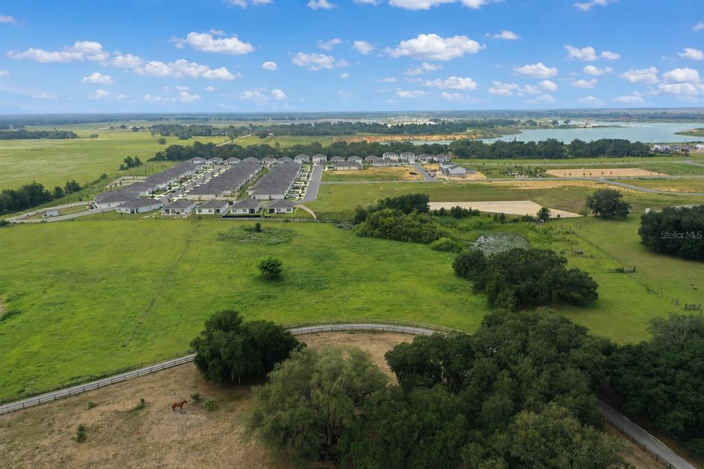 An aerial view shows a rural property with a fenced pasture and nearby residential development — 0 E HINSON AVENUE E, HAINES CITY, FL