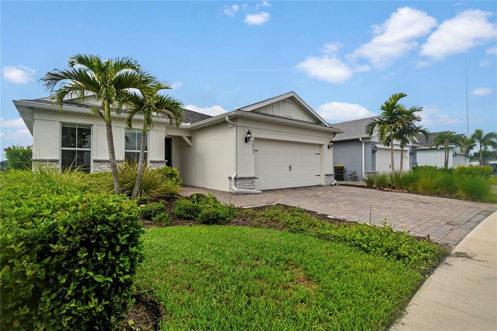 A single-story house with a paved driveway, two palm trees, and a white garage door — 42530 ATLAS DRIVE, PUNTA GORDA, FL