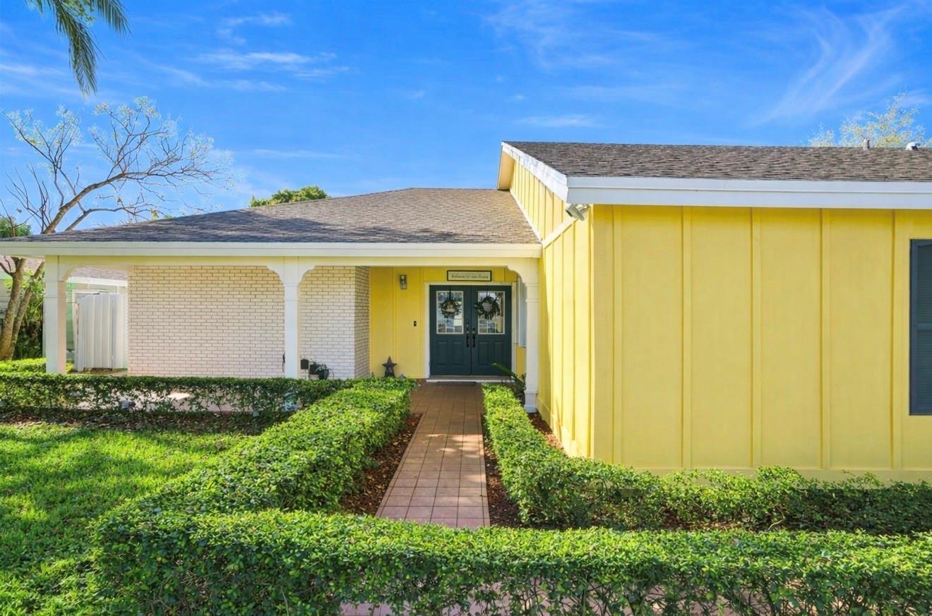 A yellow single-story house with a three-car garage and a concrete driveway under large trees — 14930 SW 145th Street, Miami FL 33196, MIAMI, FL