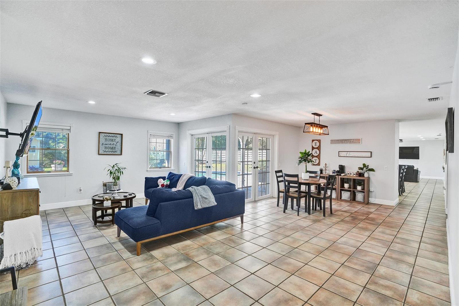 A covered patio with ceiling fans overlooks a swimming pool and a fenced backyard — 14930 SW 145th Street, Miami FL 33196, MIAMI, FL