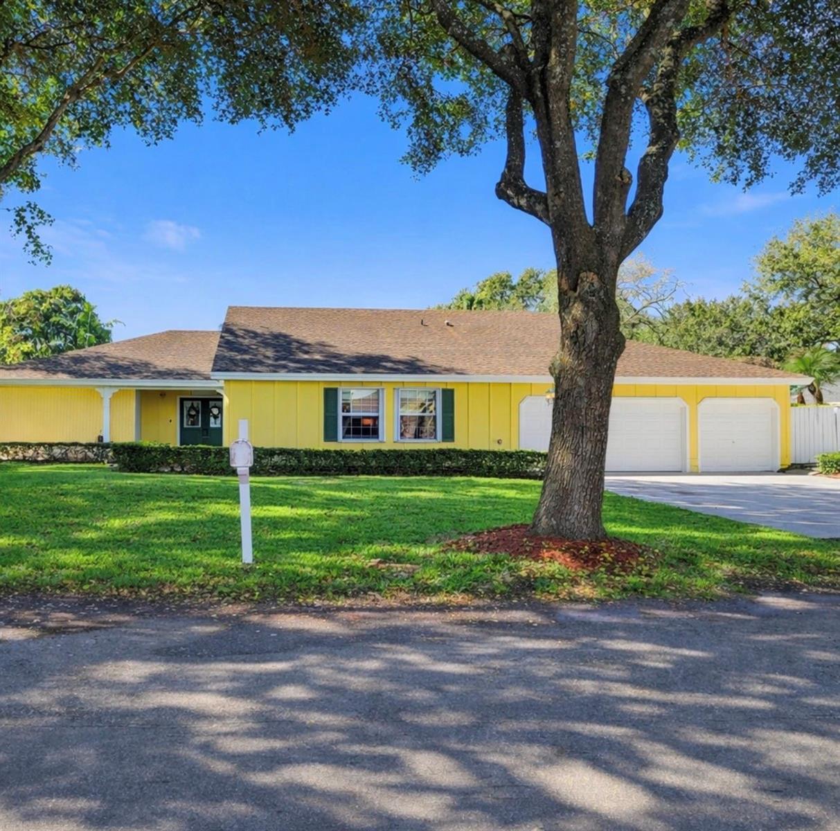 An open-concept living and dining area features tile flooring, a blue sofa, and glass doors — 14930 SW 145th Street, Miami FL 33196, MIAMI, FL