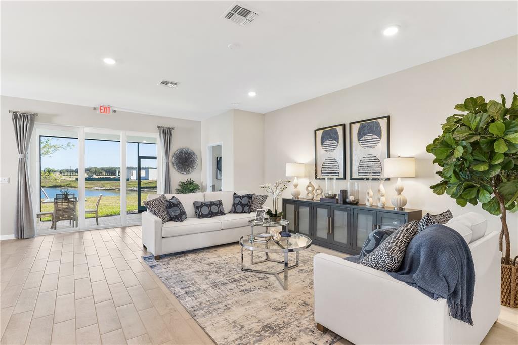 A living room features a white sofa, a glass coffee table, and sliding glass doors — 1451 MABLETON DRIVE, PORT CHARLOTTE, FL