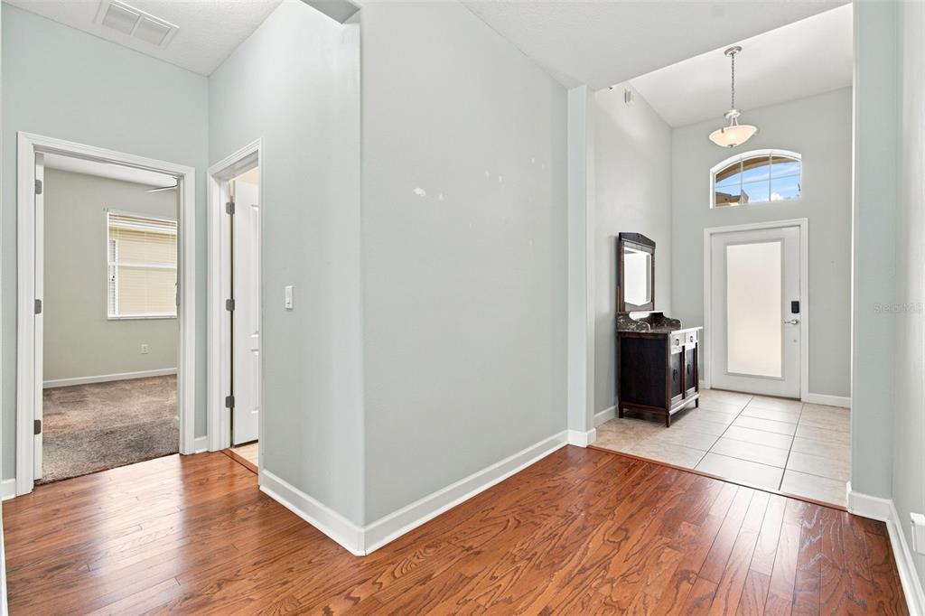 An entryway features wood flooring, a tiled foyer, a front door with a transom, and vanity — 20233 MERRY OAK AVENUE, TAMPA, FL